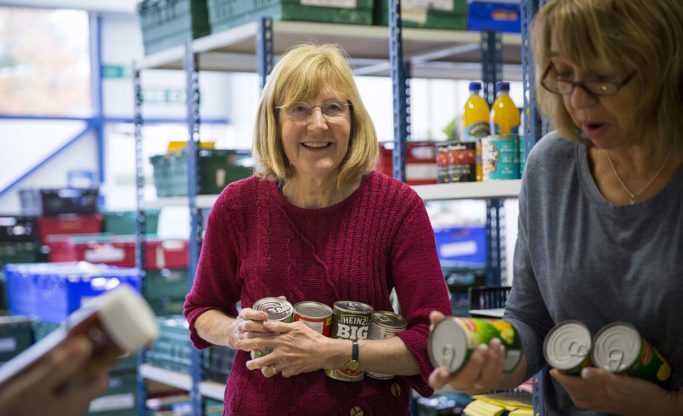 warehouse volunteers chatting about tinned food